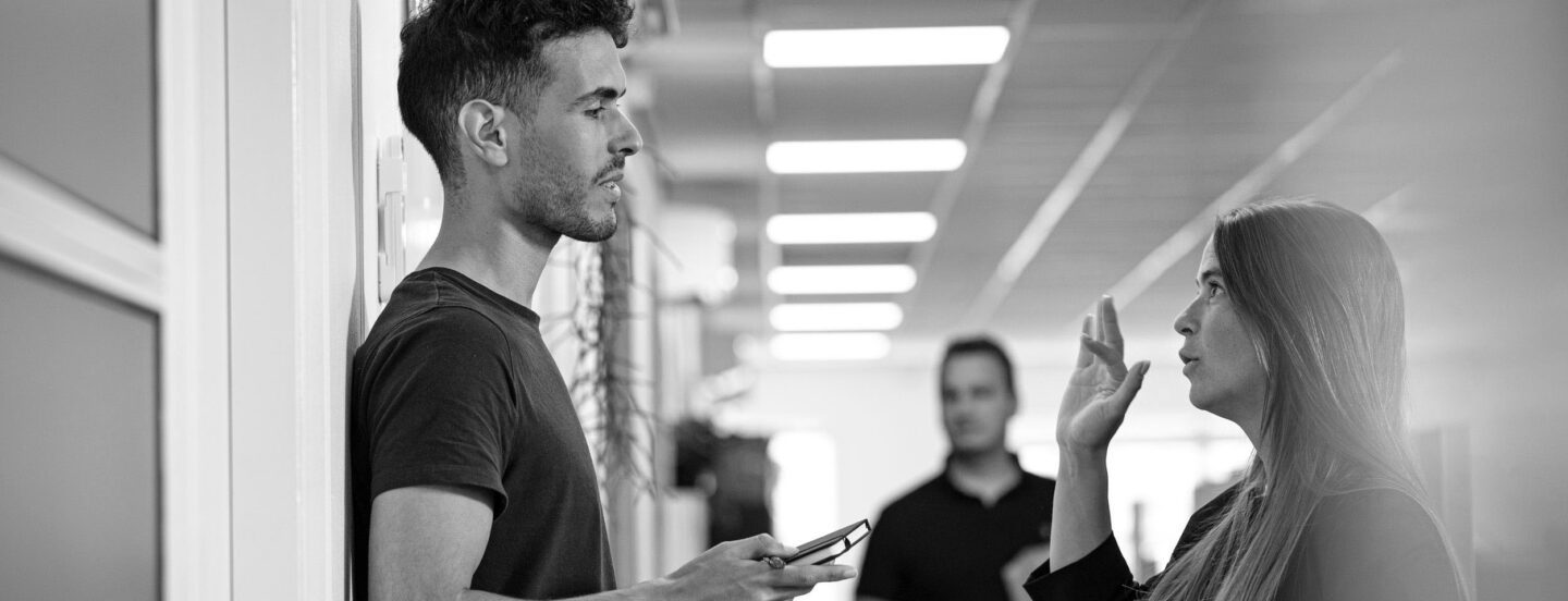 Two people in an office landscape engaged in a discussion